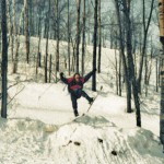 Snow-skier cresting a hill about to wipe out.