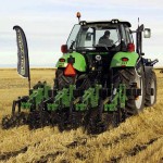 Tractor and implement working a field.