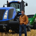 Man standing in field with a tractor.