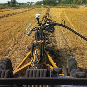 Farm equipment performing tile draining.