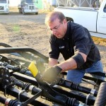 Kellen Huber of Tri Star  Farm  Services  adjusts  the  rear  harrows  to  a  less  aggressive  angle  for  seeding. 