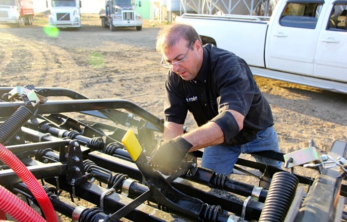 Kellen Huber of Tri Star  Farm  Services  adjusts  the  rear  harrows  to  a  less  aggressive  angle  for  seeding. 