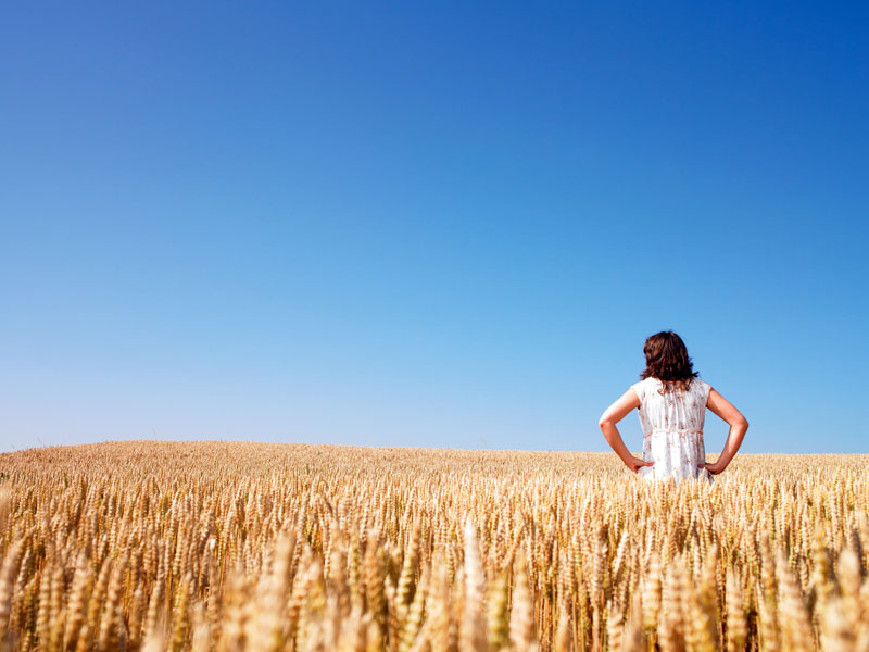 woman standing in a field of wheat