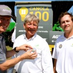 The game is on…If you think you can do a pretty good job of growing canola, the Agri-Prize Challenge announced at this week’s Ag In Motion farm show near Saskatoon is right up your alley. Farmers across Canada and northern U.S. states are being urged to register for the challenge to see who can be the first to produce a 100 bushel/acre canola crop over the next three years. Aside from the bragging rights there is a pretty decent prize that goes with the challenge. The first person to produce 100 bushels of canola on 50 acres, or the person with the highest yield after the three-year term of the contest will win the use of a whole fleet of John Deere equipment for 100 hours of field work — that includes a tractor, air seeding system, field sprayer, swather and combine. Above are representatives of contest sponsors, from left, Jon Kennedy, president of Glacier Media, he’s pinning a 100 bushel contest pin on Rob Saik, president of Agri-Trend Agrology, while Glen Walsh, with John Deere looks on. For more information visit the contest website at: www.agriprize.com.