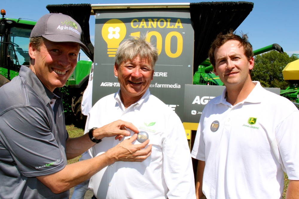 The game is on…If you think you can do a pretty good job of growing canola, the Agri-Prize Challenge announced at this week’s Ag In Motion farm show near Saskatoon is right up your alley. Farmers across Canada and northern U.S. states are being urged to register for the challenge to see who can be the first to produce a 100 bushel/acre canola crop over the next three years. Aside from the bragging rights there is a pretty decent prize that goes with the challenge. The first person to produce 100 bushels of canola on 50 acres, or the person with the highest yield after the three-year term of the contest will win the use of a whole fleet of John Deere equipment for 100 hours of field work — that includes a tractor, air seeding system, field sprayer, swather and combine. Above are representatives of contest sponsors, from left, Jon Kennedy, president of Glacier Media, he’s pinning a 100 bushel contest pin on Rob Saik, president of Agri-Trend Agrology, while Glen Walsh, with John Deere looks on. For more information visit the contest website at: www.agriprize.com.