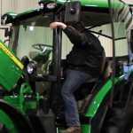 A producer takes a closer look at a John Deere 6R at this year's Ag Days in Manitoba. Loader tractors have been selling better in 2015 compared to some of their bigger counterparts.