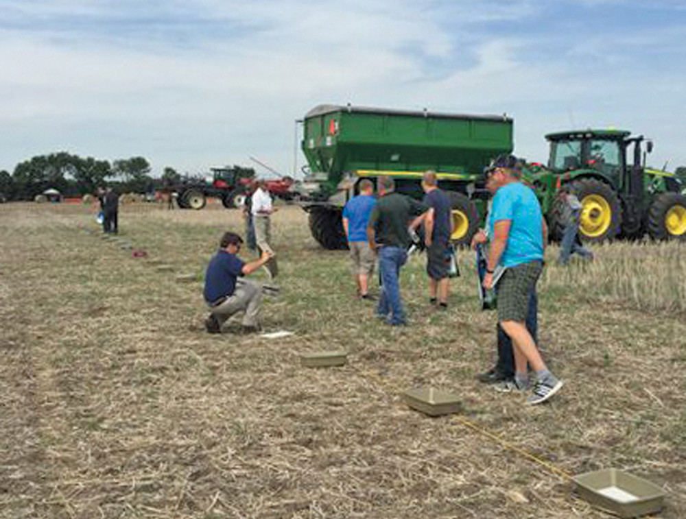 A series of collection pans are placed along the spread width to collect samples and verify the broadcast pattern.