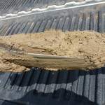 Dig the well. This is the auger, filled. Remember, just 1.5 turns. At this stage it is evident that we are well below the water table. I use a rubber glove and left hand only for cleaning to keep auger handle clean — mostly!