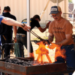 Gerd Martin, left, who spearheaded the Weyburn Ag Society farrier competition, works over hot bed of coals with competitor Todd Bailey.