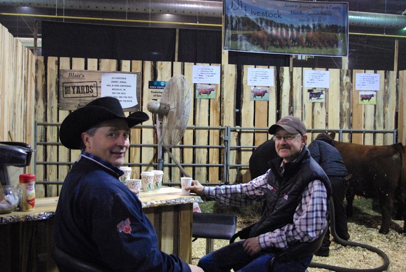 Phil Birnie of WRAZ Red Angus and Garnet Yewsiuk of V6 Livestock chatting over coffee in the JJL Livestock Booth on Thursday morning.