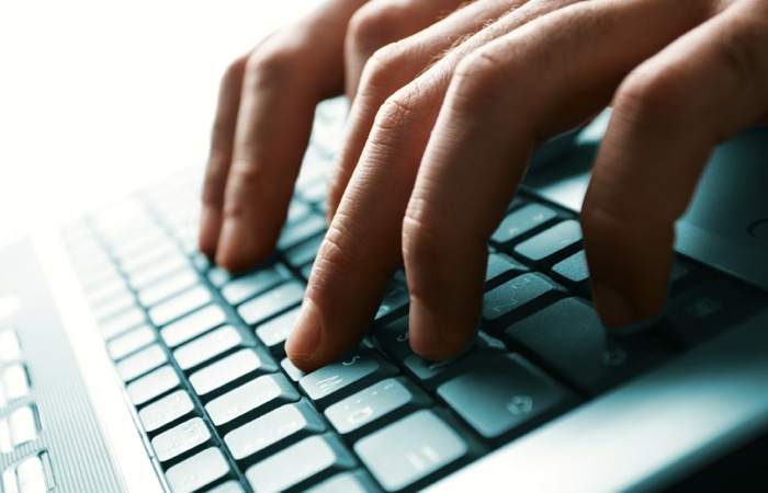 male hands typing on a laptop