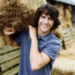 Young Farmer Carrying a Bale of Hay