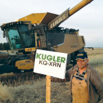 saskatchewan farmer Florian Hagmann credits several factors including good seed, decent moisture, and effective rates of liquid fertilizer products from Kugler Co. for helping him produce a field of a record-yielding 116 bushel canola crop in 2015. Albert Cochet of Birch hills (pictured) who actually combined the field for Hagmann stands next to one of the fertilizer signs.