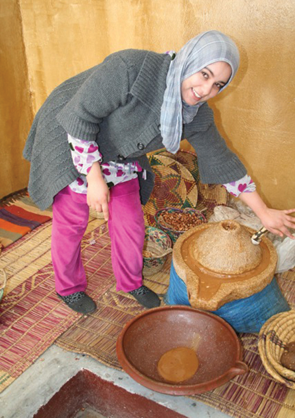 Women working in a co-operative extract the oil using a ‘quern,’ which crushes them between stones.