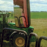 Reimer’s driverless tractor pulls alongside a combine in the field.