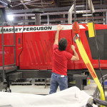 After testing, all panels are in place and a worker applies decals.