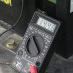Before assuming a parasitic power drain was causing the battery to go dead, we checked the charging system with a multimeter. The multimeter reading of about 14.5 volts with the tractor engine running indicated the alternator was doing its job.
