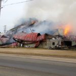 The tail end of a semi is visible as the grain elevator smoulders in Turtleford.