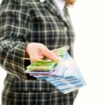 Successful woman handing out Canadian dollars. Female entrepreneur doing business in Canada. Giving or donating money. Female success in a multicultural society
