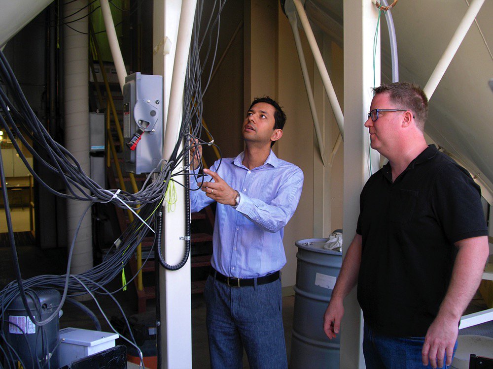 Jitendra Paliwal (left) adjusts the antennae on the 3D electromagnetic imaging system at the U of M’s grain storage research laboratory while Paul Card (right) watches.