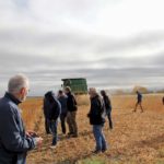 Farmers and industry reps take a look at what’s left behind the combine on the soybean plot. Some of the best soybeans are the lowest on the plant, so the cutterbar needs to be as low as possible.