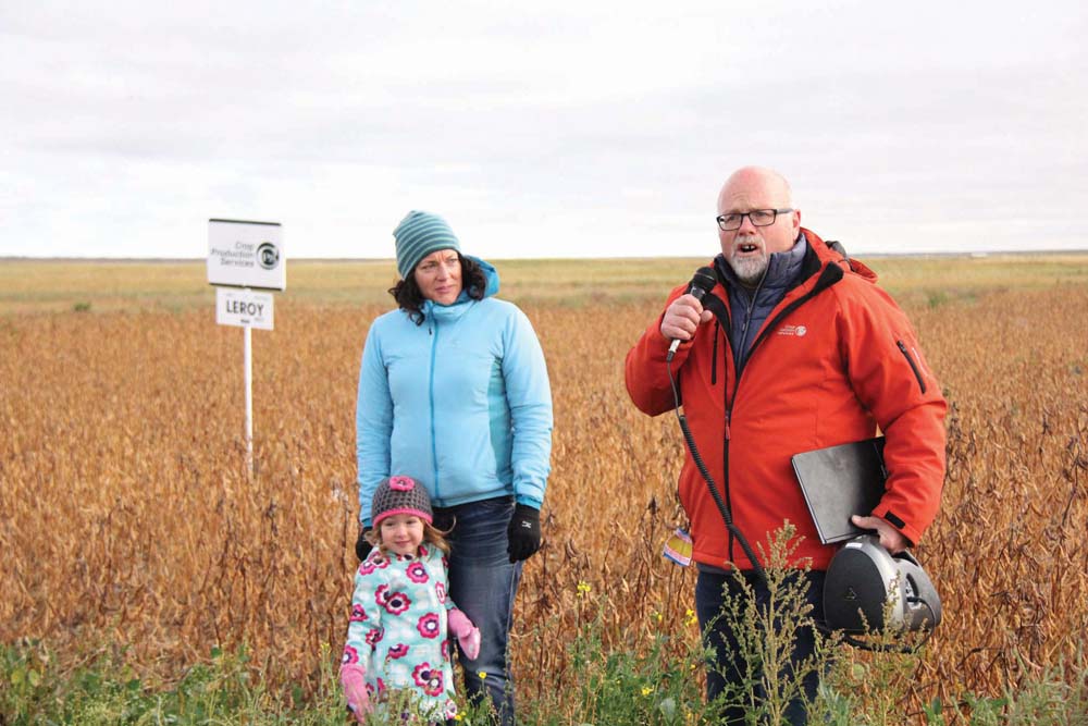 Jennifer Bogdan and Gary Sollid of Crop Production Services talk soybean agronomy at the Ag in Motion site north of Langham. Also pictured is Jennifer’s three-year-old daughter, Katla, who enjoys long walks through soybean fields.