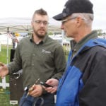 Engineer in training Alex Barrie talks with machinery editor Scott Garvey during Canada’s Outdoor Farm Show in Woodstock, Ontario.