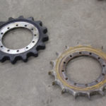 These two drive gears show the difference in wear between a new gear from another competitive brand compared to one with only 300 hours of use at the proving grounds. The abrasive conditions crated by accumulation in a closed track module accelerated the wear rate.
