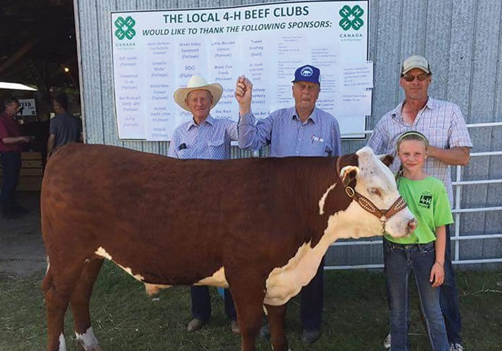Francis Poulsen, centre, with steer donated to raise funds for Manitoba Cancer Care.