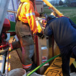 Firefighters use a silo kit and other items on hand to build a cofferdam around the 14-year-old grain entrapment victim.
