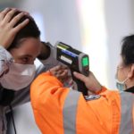 A worker checks the temperature of a passenger arriving into Hong Kong International Airport with an infrared thermometer on Feb. 7, 2020. (Photo: Reuters/Hannah McKay)
