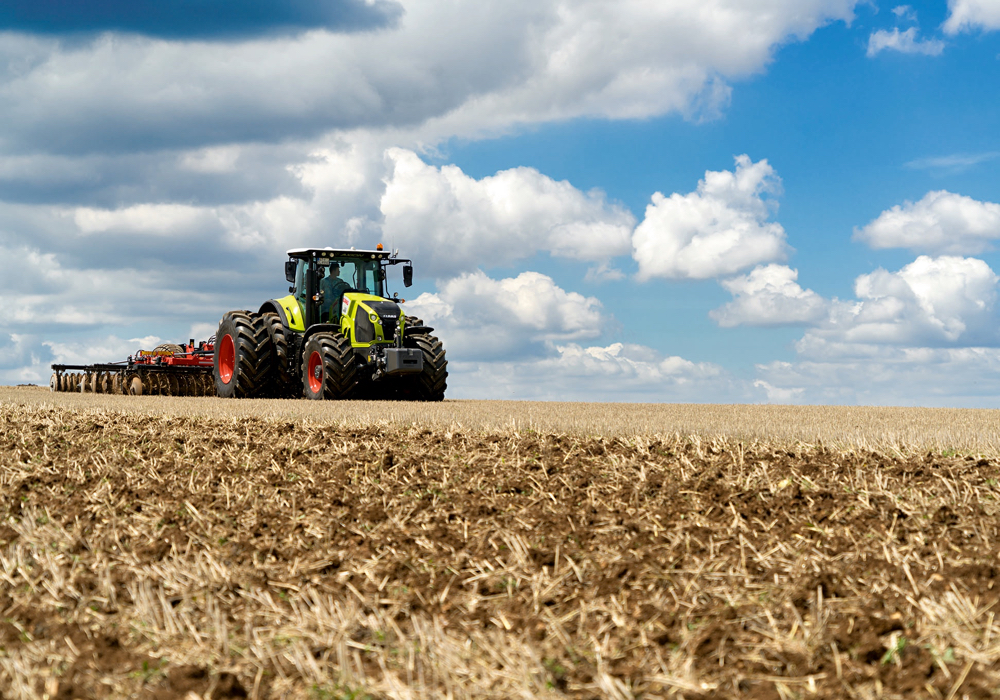In 2018 Claas introduced its 210 to 290 horsepower Axion 800 Series tractors to Canada. As the brand continues to grow the number of all-Class full-line dealers in North America, it now has even more to offer farmers with the introduction of the Axion 900 Series MFWD tractors. That pushes the brand’s MFWD horsepower range up to 445.
Power for the 900 Series comes from an 8.7 litre FPT (Fiat Powertrain) diesel — the same engine builder supplying Case IH and New Holland equipment — mated to a CVT transmission capable of creeping forward at just 2.7 feet per minute. At the top end the tractors will move down the road at 31 m.p.h. with the engine revving at only 1,750 r.p.m. The engine can run for up to 600 hours between service intervals.
When it comes to hydraulics, the tractors will pump 58 GPM through a standard four SCVs. But that number can be boosted to 6 SCVs. Both front and rear three-point hitches and PTOs are also an option.
Underneath, the 900s are available with the HD PROACTIV suspended front axle that comes equipped with brakes for better control during road transport. A four-point cab adjustable cab suspension is standard equipment to make the ride even smoother, along with an optional heated leather operator’s seat. A cooler inside the cab keeps drinks and food cold through the day. Mounted to the armrest is the brand’s CEBIS information screen.
A telematics package comes standard to help manage machinery functions, which allows for remote diagnostics by a dealer. Also an optional LED package improves vision at night
Aside from the 800 and 900 Series Axion lines, Claas continues to offer its unique Xerion rigid-frame four-wheel drives as well. Available in three models with 435 to 530 horsepower, the Xerions get their power from a 10.6 or 12.8 litre Mercedes Benz diesel engine. That power is routed through a CVT transmission.