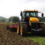 The current 8000 Series Fastrac tractors from JCB began full production in 2017. These models have seen only minor updates for 2020 and specifications for the newest model year remain essentially the same as last year. The two newest 8000 Series models pushed the Fastrac line’s top engine horsepower ratings to 280 in the 8290 and 335 in the 8330, with peak horsepower numbers hitting 306 and 348 respectively.
The equal-wheeled machines with the same mid-mounted cab and rear deck design used on the smaller 4000 Series have been signature features that defined the basic Fastrac design since its introduction in 1991, although the current 8000 Series uses slightly smaller front wheels.
The engine and transmissions under the 8000 Series hoods are from AGCO, so some parts availability stretches well beyond dedicated JCB dealers. An 8.4 litre SISU (AGCOPower) diesel mates to a programmable Fendt CVT transmission. That allows the engine management system to run the tractor at the lowest possible r.p.m. during field operations (or it can be set for other priorities like field speed) and keep torque where it needs to be while minimizing fuel consumption, even in changing field conditions. The ActivTraction feature monitors wheel slip and throttles down the engine until traction returns, and then the tractor picks up ground speed again.
The 8000 Series tractors abandoned the earlier mechanical steering linkage design for a hydrostatic dual-steer system. Two independent fluid circuits provide a fail safe system in the event of a failure in one or the other, and optional Rapid Steer changes the affect of steering wheel input based on ground speed, heightening sensitivity for low field speeds and reducing it for high road speeds.
