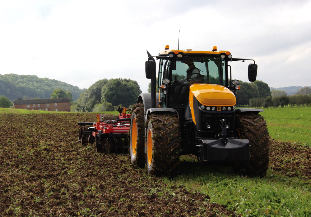 The current 8000 Series Fastrac tractors from JCB began full production in 2017. These models have seen only minor updates for 2020 and specifications for the newest model year remain essentially the same as last year. The two newest 8000 Series models pushed the Fastrac line’s top engine horsepower ratings to 280 in the 8290 and 335 in the 8330, with peak horsepower numbers hitting 306 and 348 respectively. 
The equal-wheeled machines with the same mid-mounted cab and rear deck design used on the smaller 4000 Series have been signature features that defined the basic Fastrac design since its introduction in 1991, although the current 8000 Series uses slightly smaller front wheels.
The engine and transmissions under the 8000 Series hoods are from AGCO, so some parts availability stretches well beyond dedicated JCB dealers. An 8.4 litre SISU (AGCOPower) diesel mates to a programmable Fendt CVT transmission. That allows the engine management system to run the tractor at the lowest possible r.p.m. during field operations (or it can be set for other priorities like field speed) and keep torque where it needs to be while minimizing fuel consumption, even in changing field conditions. The ActivTraction feature monitors wheel slip and throttles down the engine until traction returns, and then the tractor picks up ground speed again.
The 8000 Series tractors abandoned the earlier mechanical steering linkage design for a hydrostatic dual-steer system. Two independent fluid circuits provide a fail safe system in the event of a failure in one or the other, and optional Rapid Steer changes the affect of steering wheel input based on ground speed, heightening sensitivity for low field speeds and reducing it for high road speeds.