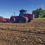 MTZ Equipment continues to offer the 435 horsepower Russian-built Kirovets K744 to the big-tractor market in Canada, and with a base price of $289,000 (as of 2019), their market advantage still comes down to basic horsepower at a lower cost. Although the current machines don’t offer sophisticated, high-end electronics, they do have more than a few modern features to offer.
Powering the K744 is a Tier 4-compliant turbocharged Mercedes Benz diesel. Behind the German engine is a 16-speed partial powershift allowing four on-the-go gear changes within each of four forward ranges.
Moving the hydraulic pump from under the cab and changing control mechanisms a couple of years ago has also allowed for a much quieter cab. And air ride cab suspension has been made standard.
The drawbar tongue load rating is 11,000 pounds up from the previous 4,000 on earlier versions. Tire size availability ranges up to 710/70R38s. Wide Mitas 1050 tires are also an option. Bolt-on track modules with 30- or 36-inch rubber belts are available as well. No internal driveline changes are necessary to handle tracks. The brand claims the components in the system are overbuilt for durability and can easily handle both tires and tracks.
The tractor rides on a suspended front axle and has a 74 GPM (280 l/min.) hydraulic flow rate. It comes equipped with a category III and IV three-point rear hitch, which has a lift capacity of 9,000 kilograms.
K744s use a dedicated pump for power steering and the transmission demands. So the full 74 GPM flow is available for implements. There are five hydraulic outlets (one of them is connected to the three-point hitch). Each one can deliver up to 37 GPM (140 l/min.) per outlet.