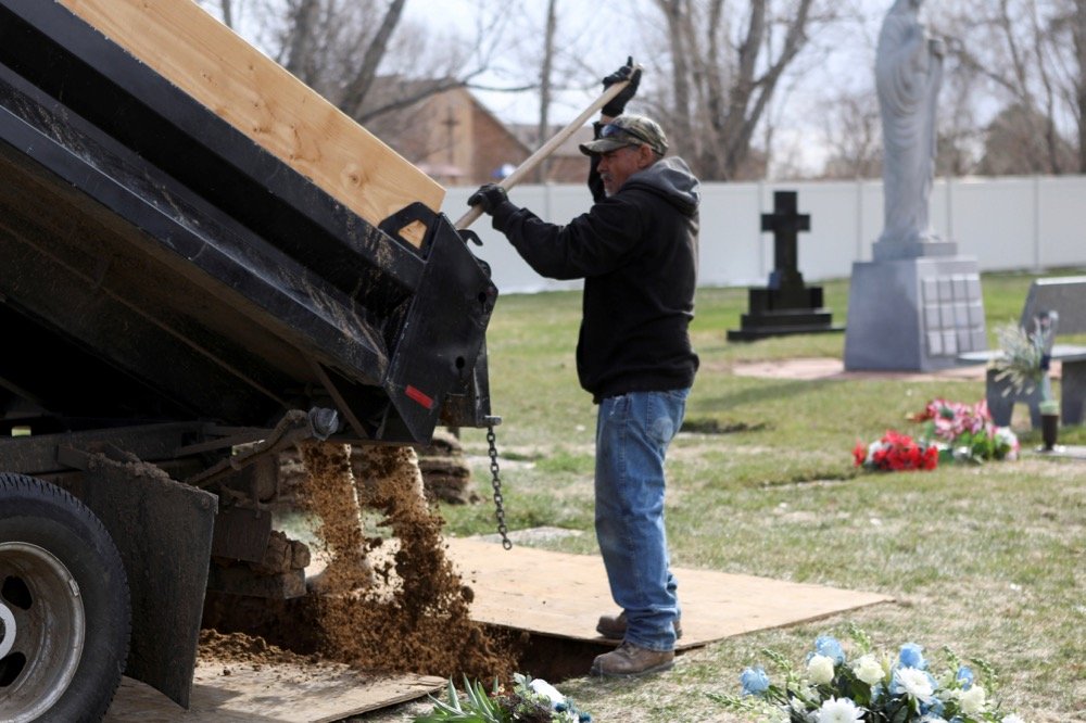 Cemetery employees fill in the grave of JBS USA meat packing plant employee Saul Sanchez on April 15, 2020 at Greeley, Colorado, following his death from COVID-19. (Photo: Reuters/Jim Urquhart)
