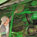 Chris Plett of CPC Ag Repair points out a common failure point on the unloading system when harvesting wet grain.
