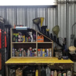 Previously, this was our grease table/lubrication shelf. I built a funnel rack (each funnel drains into a container at the bottom of the pipe) and a grease-gun holder out of ABS pipe, augmented an old shelving unit to fit under the rack for aerosols and mounted a towel dispenser to it.