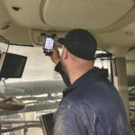 Ben Cavers scans one of the QR codes posted in the cab of a farm tractor. Whether it’s for Cavers, another member of the family farm or a hired worker, the code hosts a wide range of information including photos and short, homemade videos on how to operate a piece of equipment.