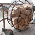 A couple of steel rims off old wooden wagon wheels can be welded with spacers to create an attractive, useful and history filled firewood holder.