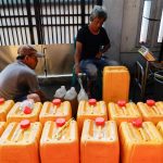Workers fill jerrycans with cooking oil at a distribution station in Jakarta, Indonesia on May 20, 2022. (Photo: Reuters/Willy Kurniawan)