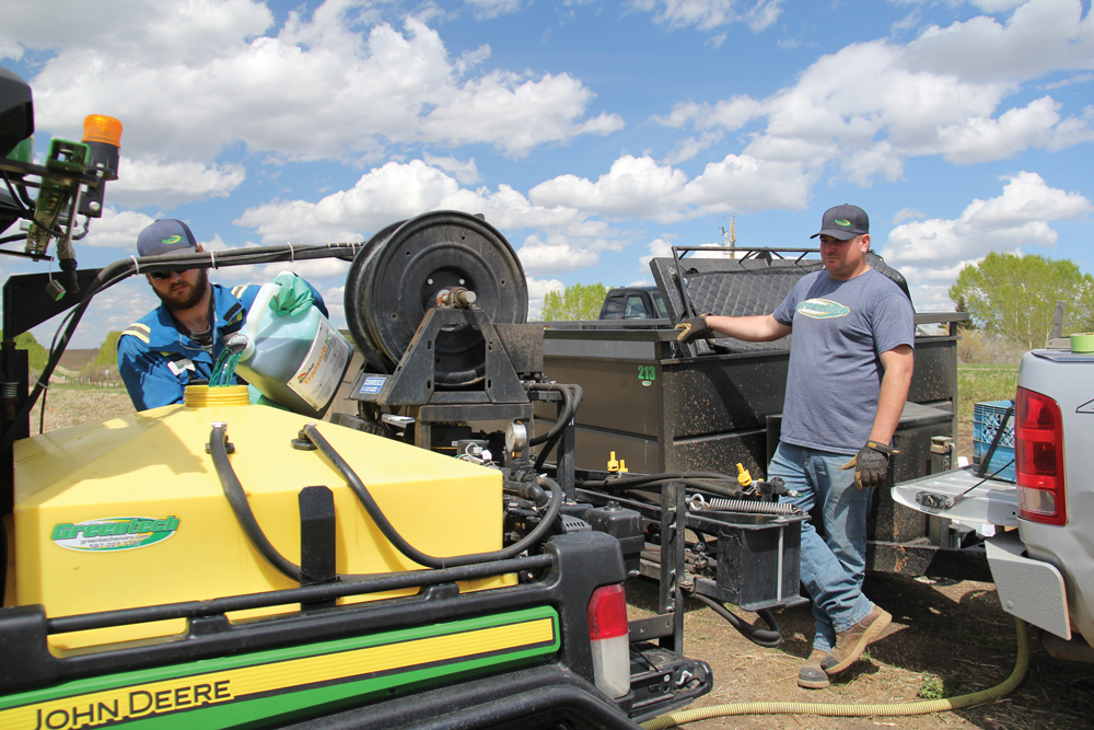 Braden Madsen, left, with Greentech Enviro
Solutions loads chemical into the 100 gallon
tank on the UTV field sprayer built by
Greentech general manager Jeremiah
Kanderka. These compact sprayer units are
ideal for applying chemicals to smaller fields
and for range and pasture land use.