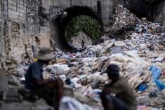 A man looks through piles of trash on a stream in Port-au-Prince, Haiti on Oct. 13, 2022. (Photo: Reuters/Ricardo Arduengo)
