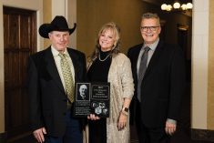 Alumni of Canada’s Outstanding Young Farmers program Ian (left) and Karilynn (middle) Marshall of Bowden, Alta., receive the W.R. Motherwell Award from COYF president, Danny Penner (right), at the COYF national award ceremony in November.