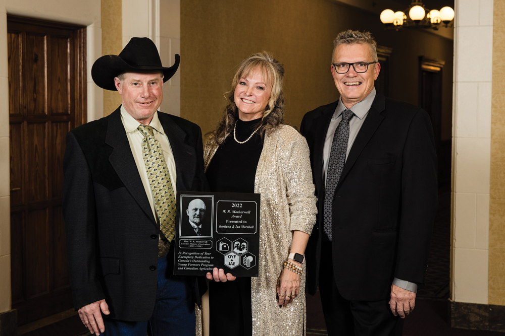 Alumni of Canada’s Outstanding Young Farmers program Ian (left) and Karilynn (middle) Marshall of Bowden, Alta., receive the W.R. Motherwell Award from COYF president, Danny Penner (right), at the COYF national award ceremony in November.