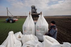 A farm worker unloads Ukrainian-made fertilizer from a truck on April 5, 2022 to use on a wheat field near the village of Yakovlivka, outside Kharkiv, after it was hit by an aerial bombardment. (Photo: Reuters/Thomas Peter)