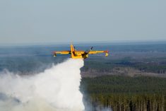 File photo of a CL 215 water bomber passing over a Canadian forest fire. 