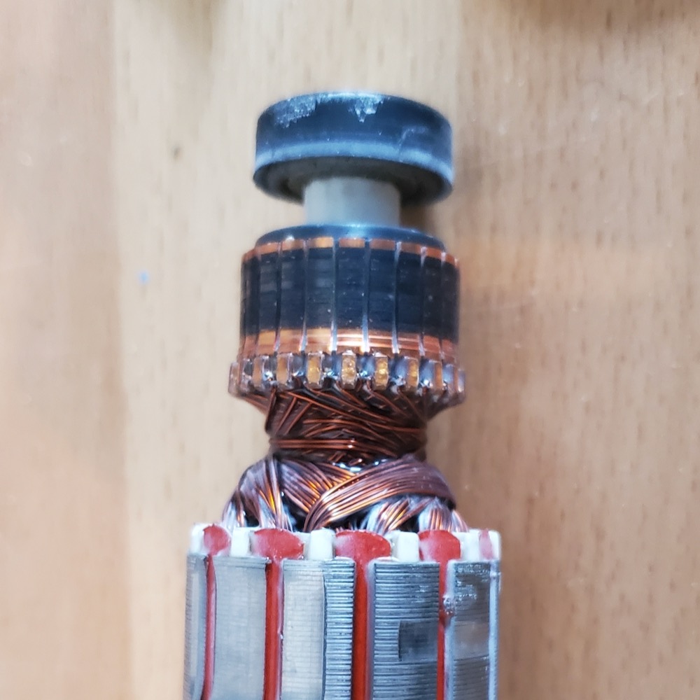 A copper commutator on the left side is coated with carbon.