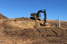After carefully filling in around the well, Dan Mitchell makes a pad for the trough, then works on sloping the hillside behind so that the animals don’t have a drop off.