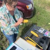 Louise Carduner marks a kernel and then counts the rows during a Manitoba-Saskatchewan one-woman corn crop tour.